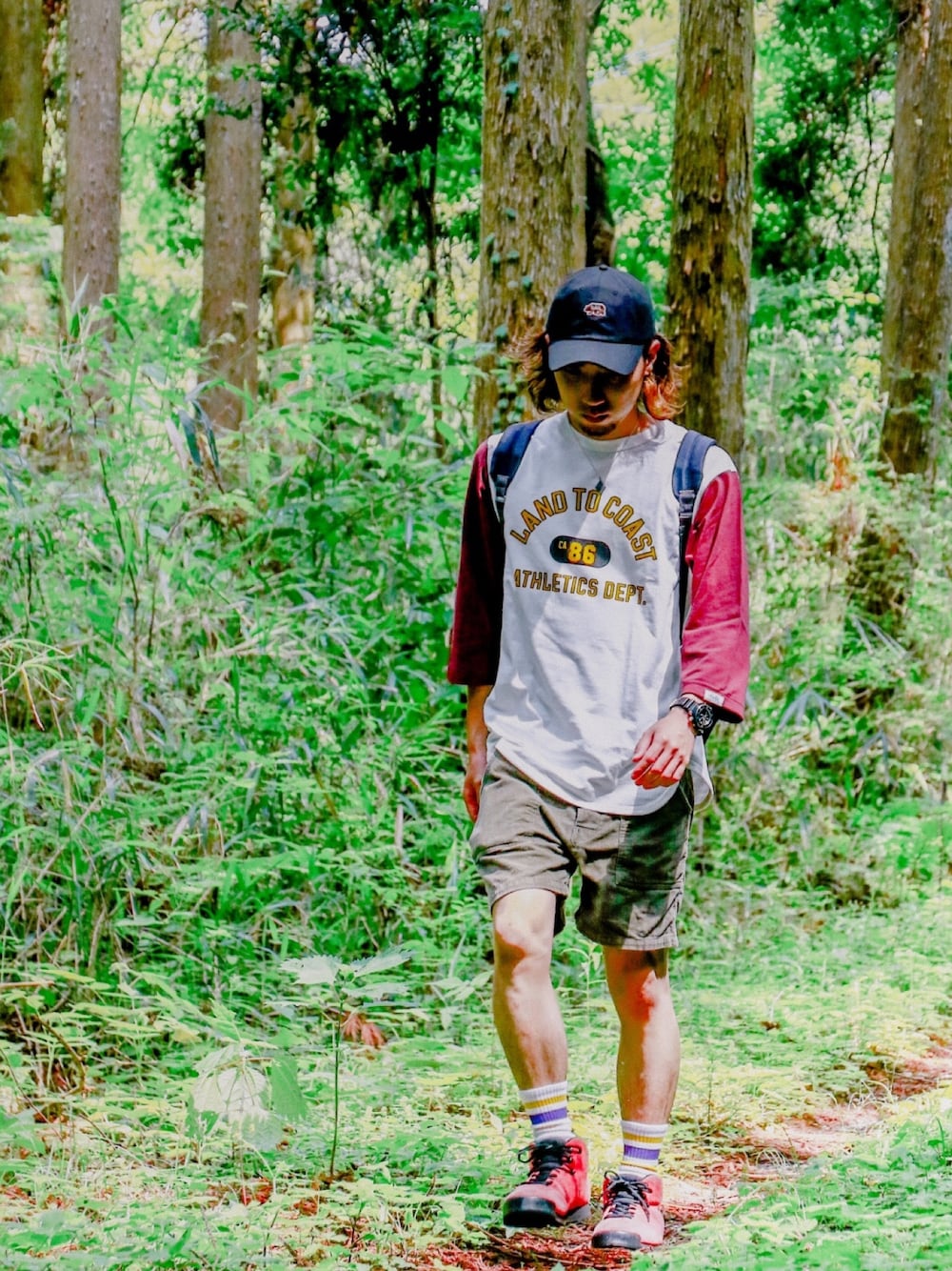 レッド系のTシャツ/カットソー、グリーン系のパンツ、レッド系のスニーカーを着用したメンズの夏コーディネートの1枚目の写真