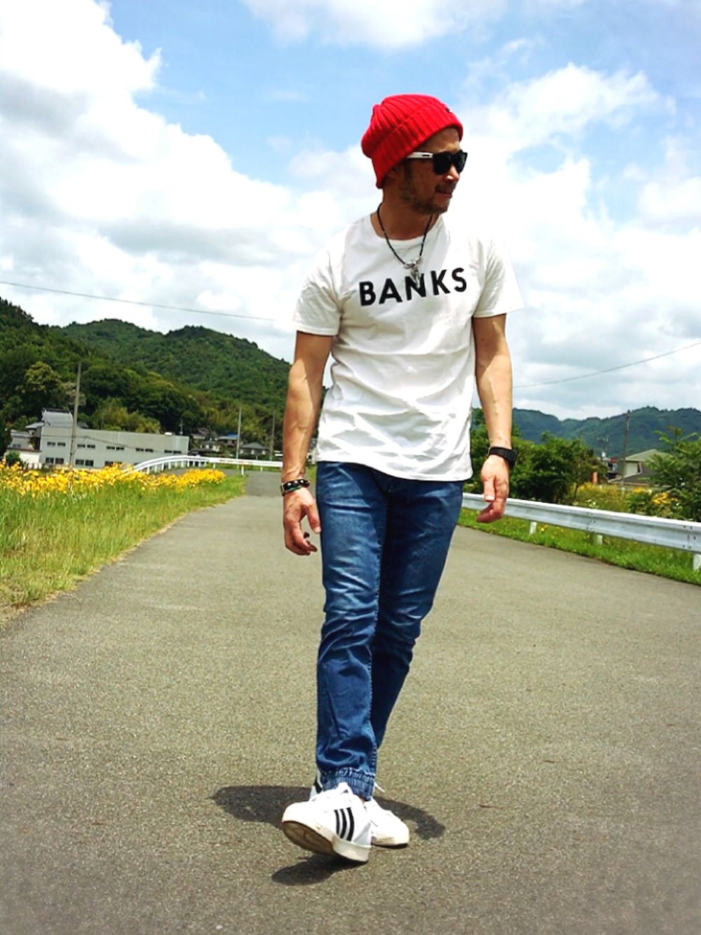 ホワイト系のスニーカー、ブルー系のデニムパンツ、ホワイト系のTシャツ/カットソーを着用したメンズの春コーディネートの1枚目の写真