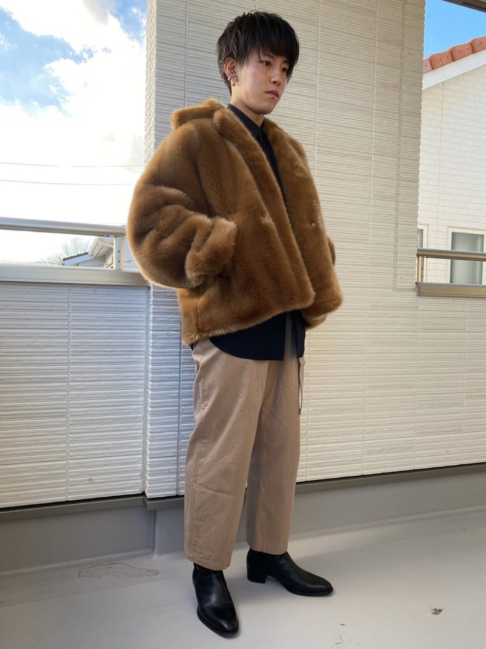 ベージュ系のその他アウター、ブラック系のシャツ/ブラウス、ベージュ系のチノパンツを着用したメンズの冬コーディネートの1枚目の写真