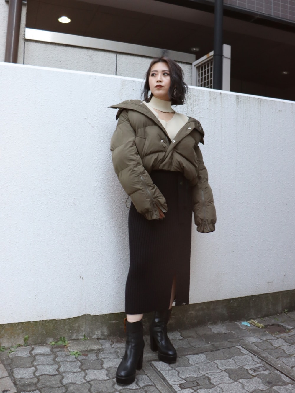 グリーン系のダウンジャケット/コート、ブラック系のブーツを着用したレディースの秋コーディネートの1枚目の写真