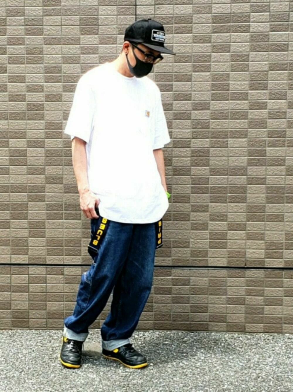 ブルー系のデニムパンツ、ブラック系のスニーカー、ホワイト系のTシャツ/カットソーを着用したメンズの春コーディネートの1枚目の写真