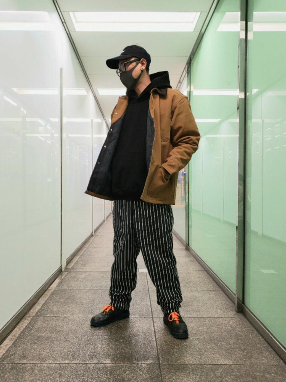 ブラック系のパンツ、ブラック系のスニーカー、ブラック系のパーカーを着用したメンズの冬コーディネートの1枚目の写真