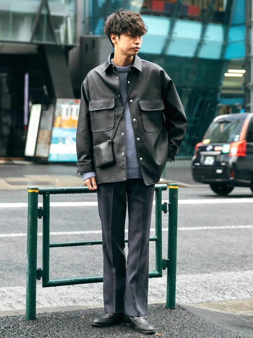 ブラック系のその他アウター、ブルー系のニット/セーター、グレー系のパンツを着用したメンズの秋コーディネートの1枚目の写真