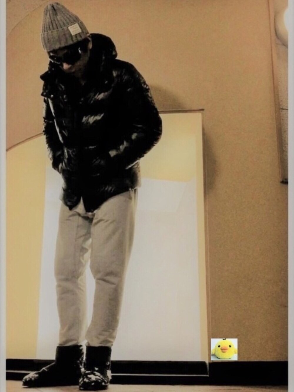 ブラック系のダウンジャケット/コート、グレー系のその他パンツ、ブラック系のTシャツ/カットソーを着用したメンズの冬コーディネートの1枚目の写真