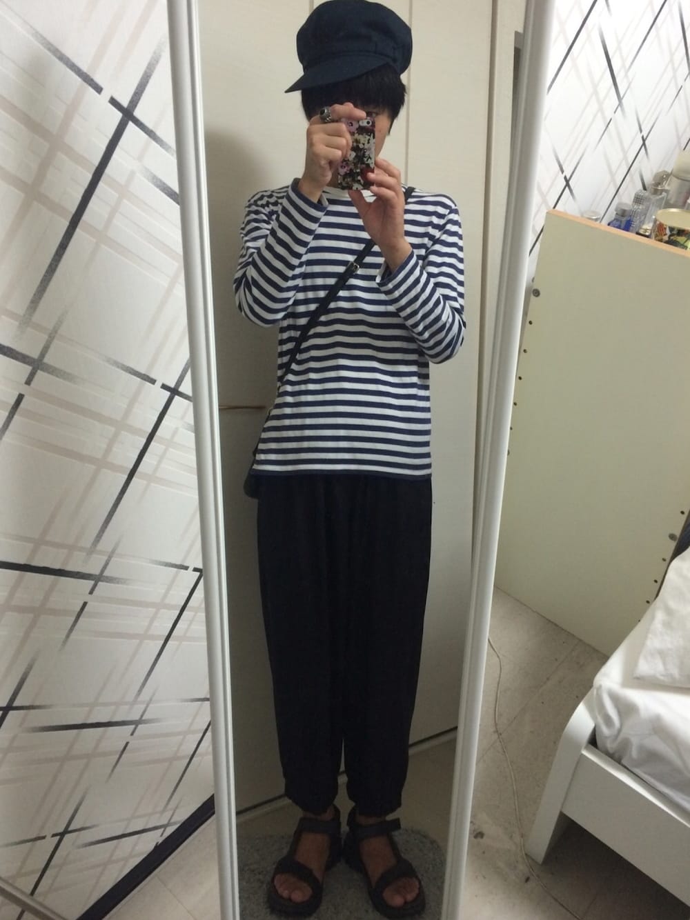 ホワイト系のTシャツ/カットソー、ブルー系のその他パンツ、ブラック系のサンダルを着用したメンズの秋コーディネートの1枚目の写真