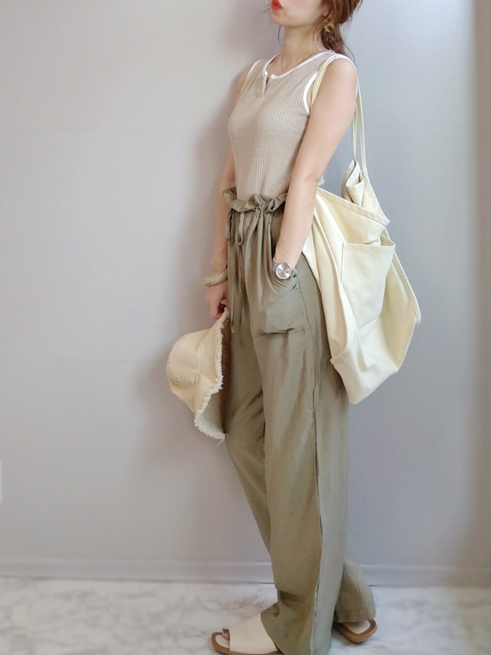 ベージュ系のタンクトップ、グリーン系のその他パンツ、ホワイト系のトートバッグを着用したレディースの夏コーディネートの1枚目の写真