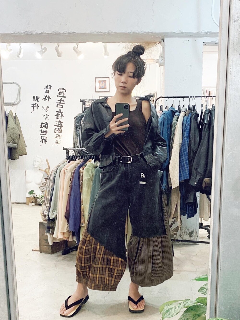 ブラック系のムートンコート、ブラック系のデニムパンツ、ブラック系のベルトを着用したレディースの秋コーディネートの1枚目の写真