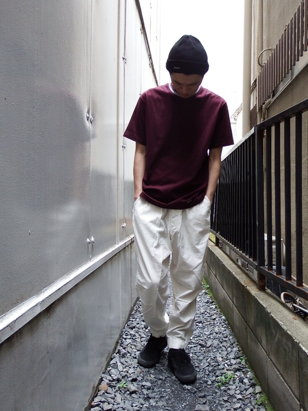 レッド系のTシャツ/カットソー、ホワイト系のその他パンツ、ブラック系のニットキャップ/ビーニーを着用したメンズの春コーディネートの1枚目の写真