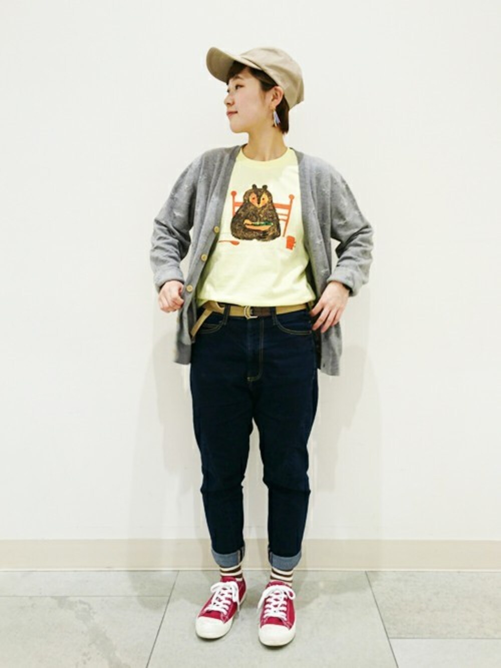 イエロー系のTシャツ/カットソー、グレー系のカーディガン/ボレロを着用したレディースの冬コーディネートの1枚目の写真