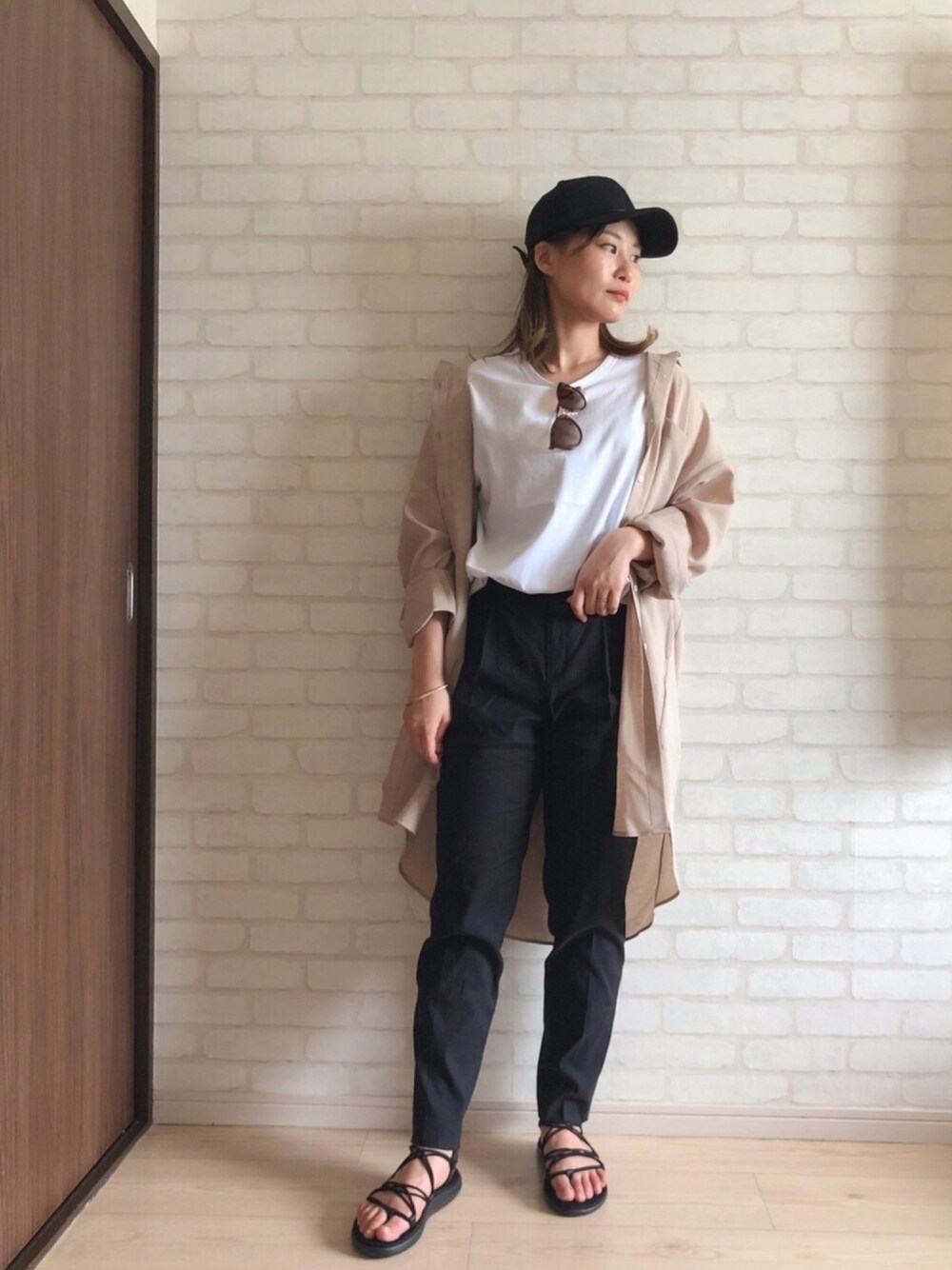 ブラック系のその他パンツ、ブラック系のサンダル、ベージュ系のシャツ/ブラウスを着用したレディースの春コーディネートの1枚目の写真