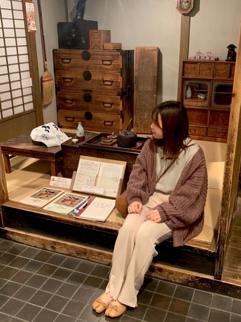 ブラウン系のカーディガン/ボレロ、グリーン系のTシャツ/カットソー、ベージュ系のパンプスを着用したレディースの春コーディネートの1枚目の写真