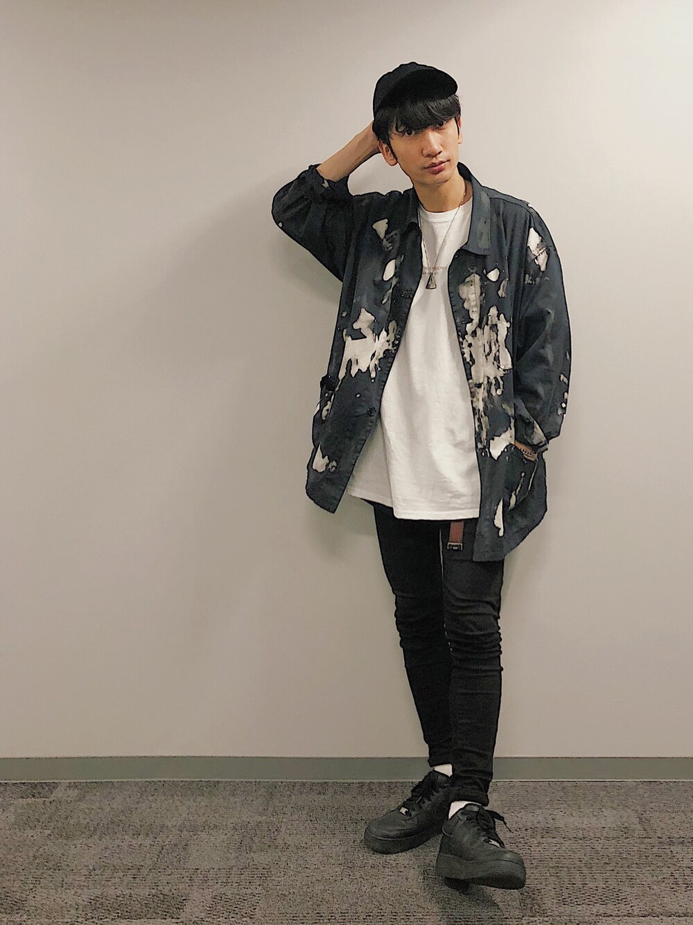 ブラック系のミリタリージャケット、ブラック系のデニムパンツ、ブラック系のスニーカーを着用したメンズの秋コーディネートの1枚目の写真