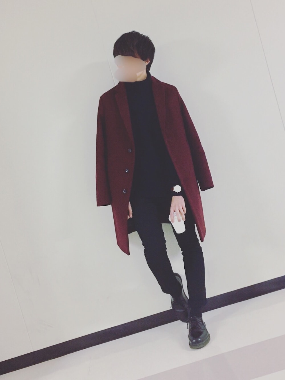 レッド系のチェスターコート、ブラック系のニット/セーター、ブラック系のパンツを着用したメンズの冬コーディネートの1枚目の写真