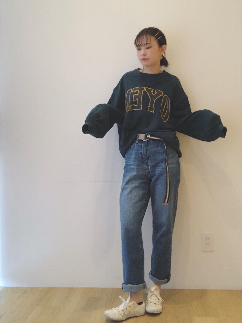 グリーン系のTシャツ/カットソー、ブルー系のデニムパンツ、ブルー系のベルトを着用したレディースの秋コーディネートの1枚目の写真