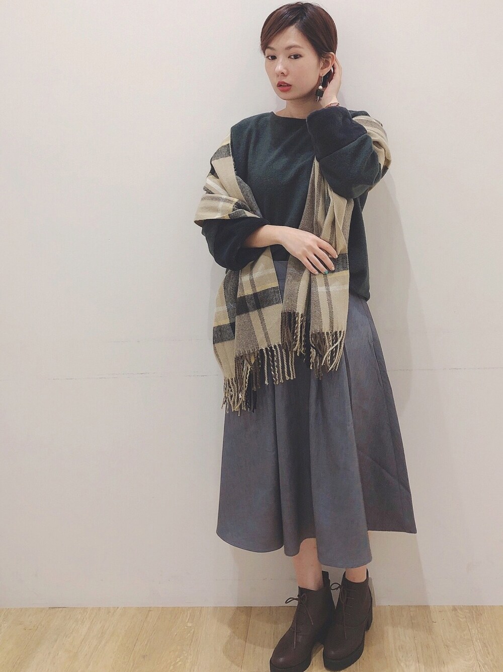 ブラウン系のブーツ、グリーン系のワンピース、レッド系のストール/ショールを着用したレディースの秋コーディネートの1枚目の写真