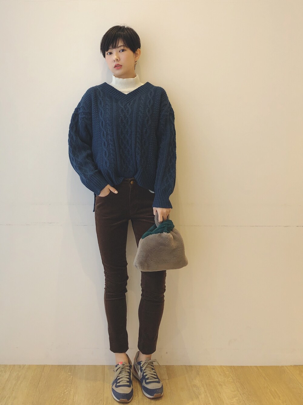 ブルー系のニット/セーター、ホワイト系のニット/セーター、ブラウン系のその他パンツを着用したレディースの秋コーディネートの1枚目の写真