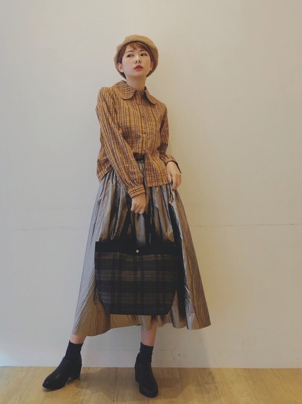 イエロー系のシャツ/ブラウス、グリーン系のトートバッグ、ゴールド系のスカートを着用したレディースの冬コーディネートの1枚目の写真