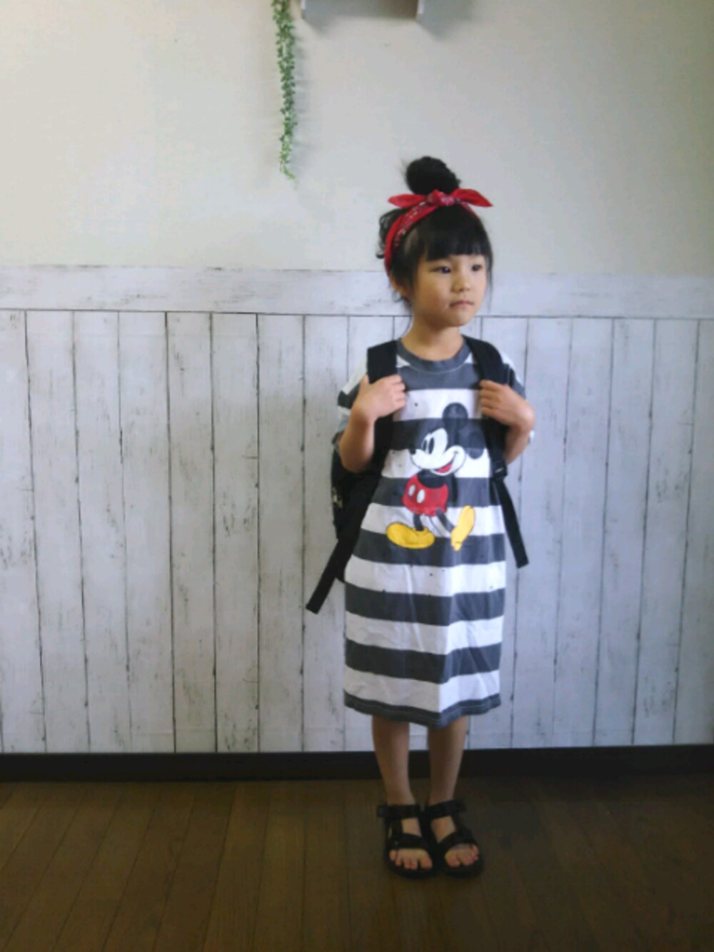 ホワイト系のワンピース、ブラック系のバックパック/リュック、ブラック系のサンダルを着用したキッズの春コーディネートの1枚目の写真