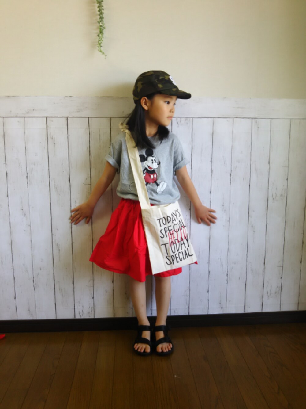 グレー系のTシャツ/カットソー、レッド系のスカート、ホワイト系のショルダーバッグを着用したキッズの春コーディネートの1枚目の写真