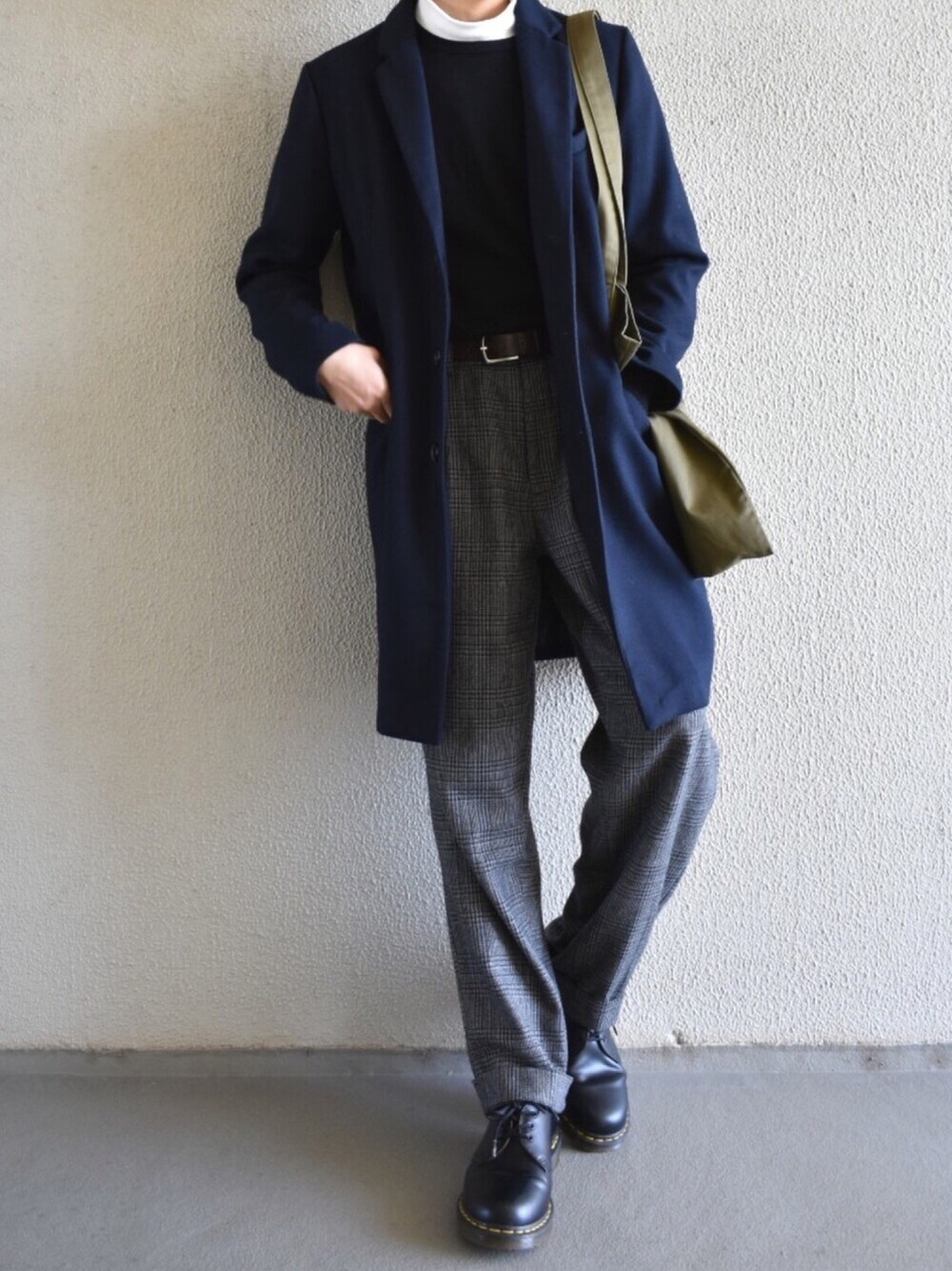 ブルー系のチェスターコート、グレー系のパンツ、ブラック系のニット/セーターを着用したメンズの冬コーディネートの1枚目の写真