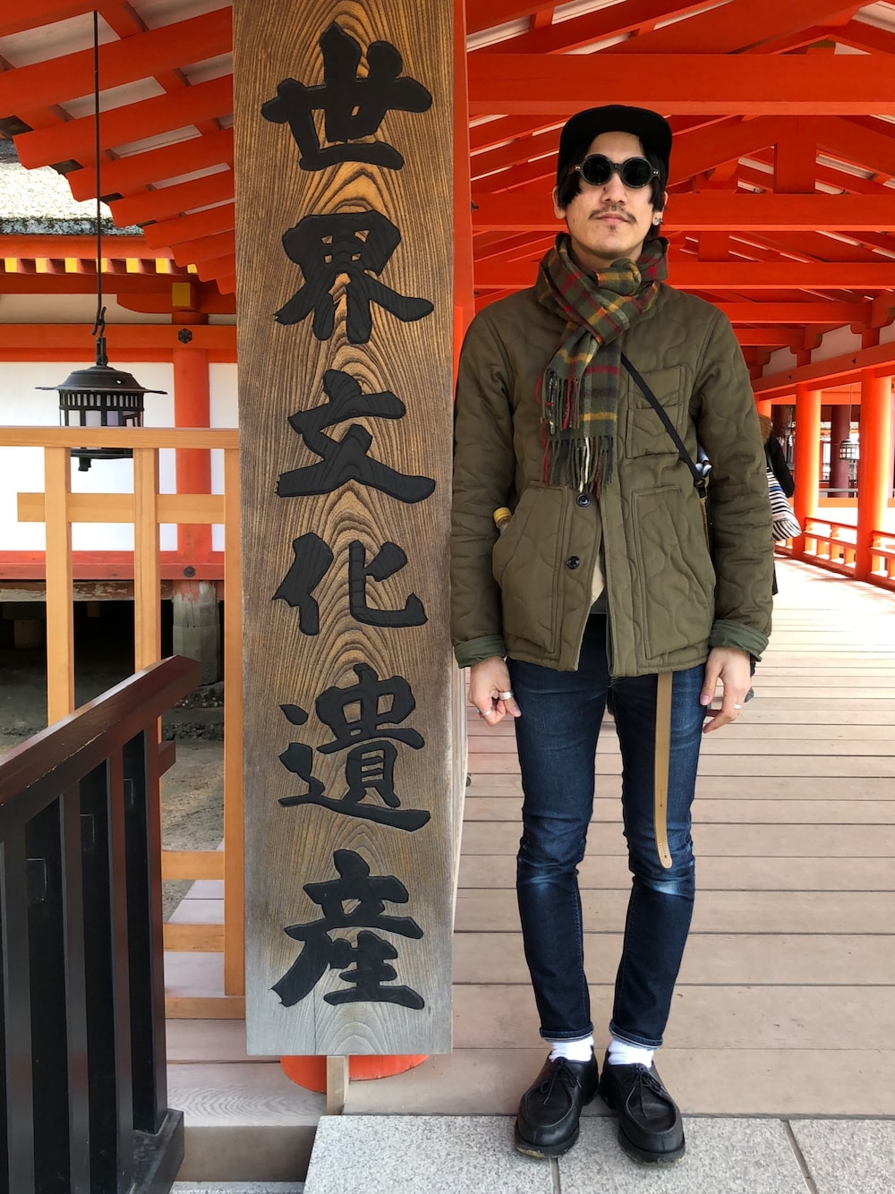 グリーン系のノーカラージャケット、ベージュ系のベスト、ブルー系のデニムパンツを着用したメンズの春コーディネートの1枚目の写真