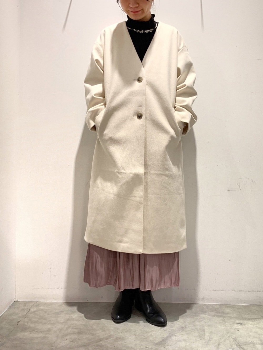 ブラック系のニット/セーター、ホワイト系のノーカラーコート、パープル系のスカートを着用したレディースの秋コーディネートの1枚目の写真