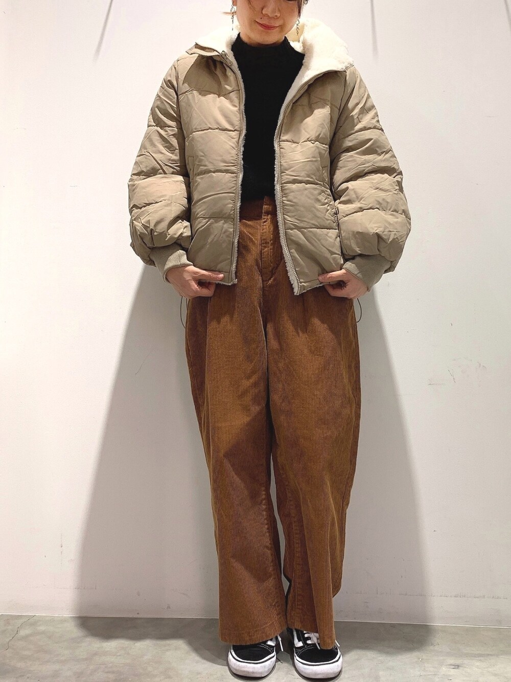 ホワイト系のその他アウター、イエロー系のその他パンツ、ブラック系のニット/セーターを着用したレディースの冬コーディネートの1枚目の写真