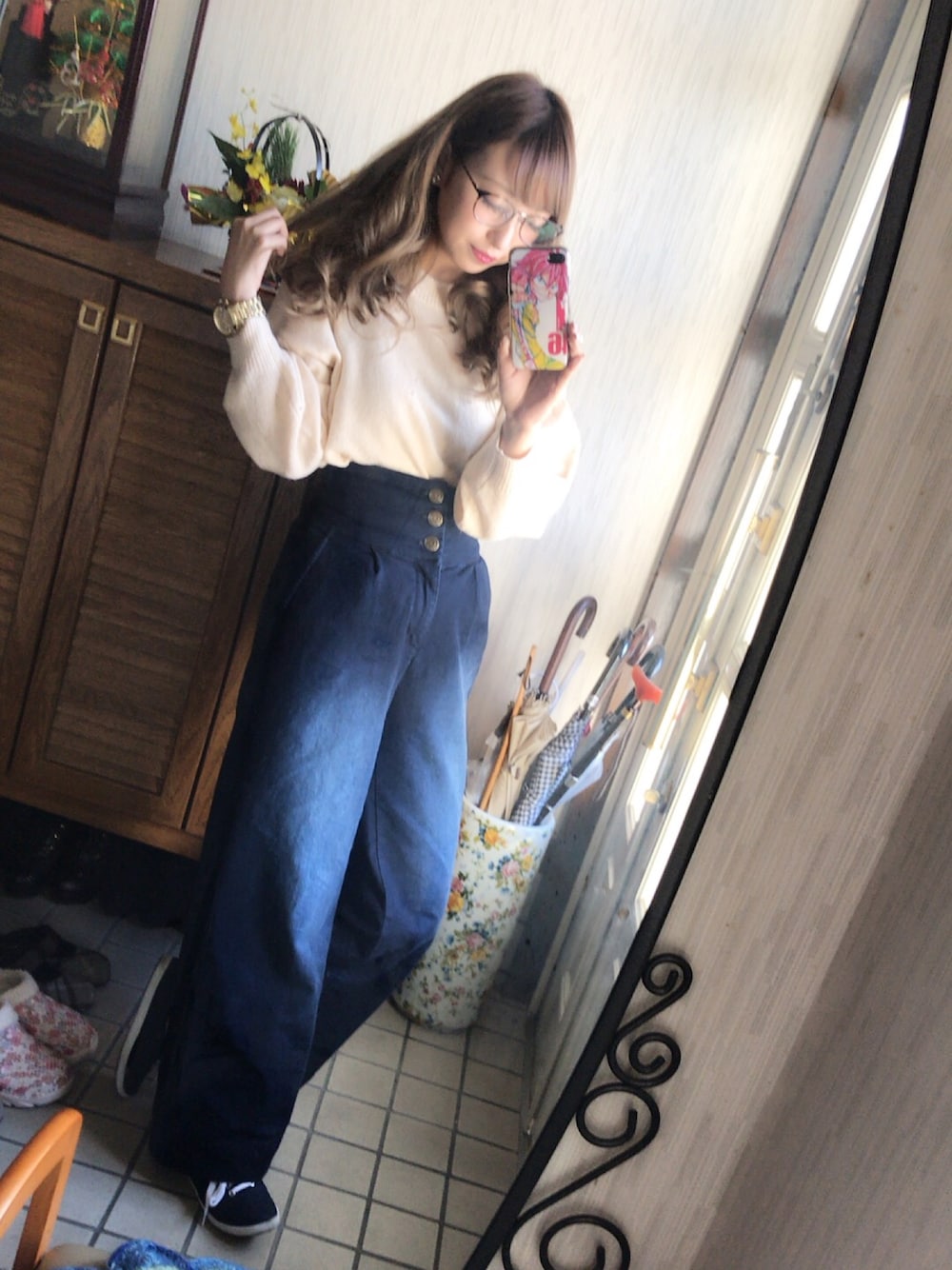 ピンク系のトップス、ブルー系のデニムパンツ、ブルー系のスニーカーを着用したレディースの冬コーディネートの1枚目の写真