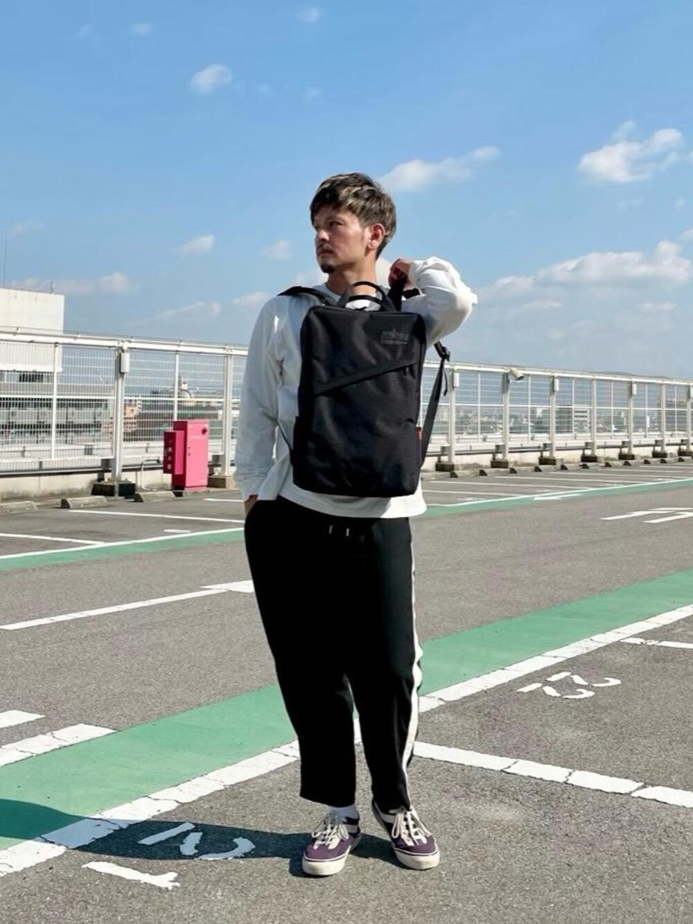 ブラック系のバックパック/リュック、ホワイト系のTシャツ/カットソーを着用したメンズの秋コーディネートの1枚目の写真