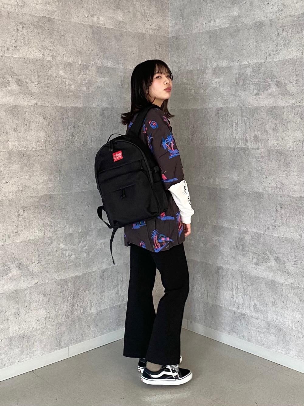 ブラック系のバックパック/リュック、ホワイト系のTシャツ/カットソー、ブラック系のシャツ/ブラウスを着用したレディースの春コーディネートの1枚目の写真