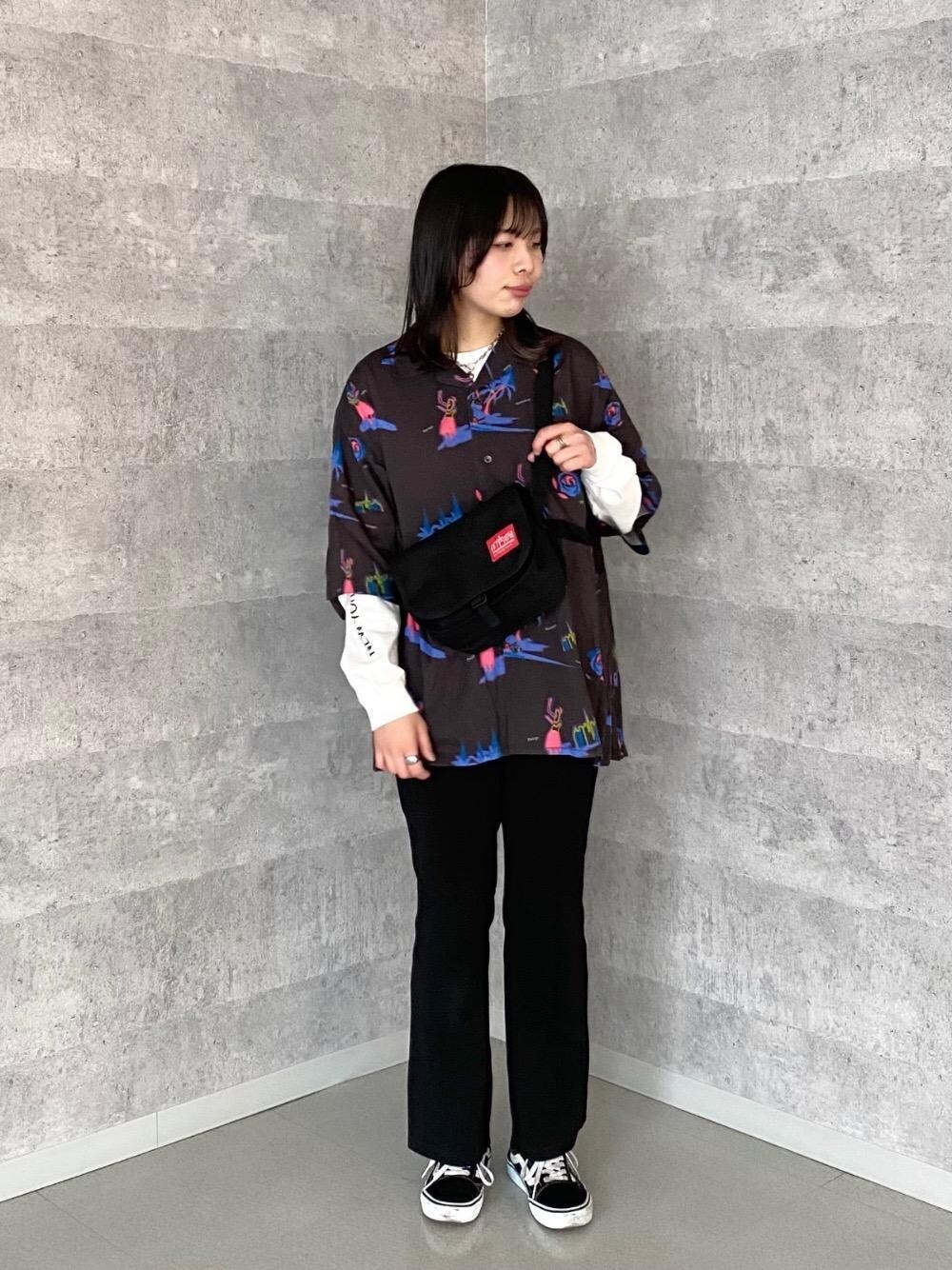 ブラック系のショルダーバッグ、ホワイト系のTシャツ/カットソー、ブラック系のシャツ/ブラウスを着用したレディースの春コーディネートの1枚目の写真