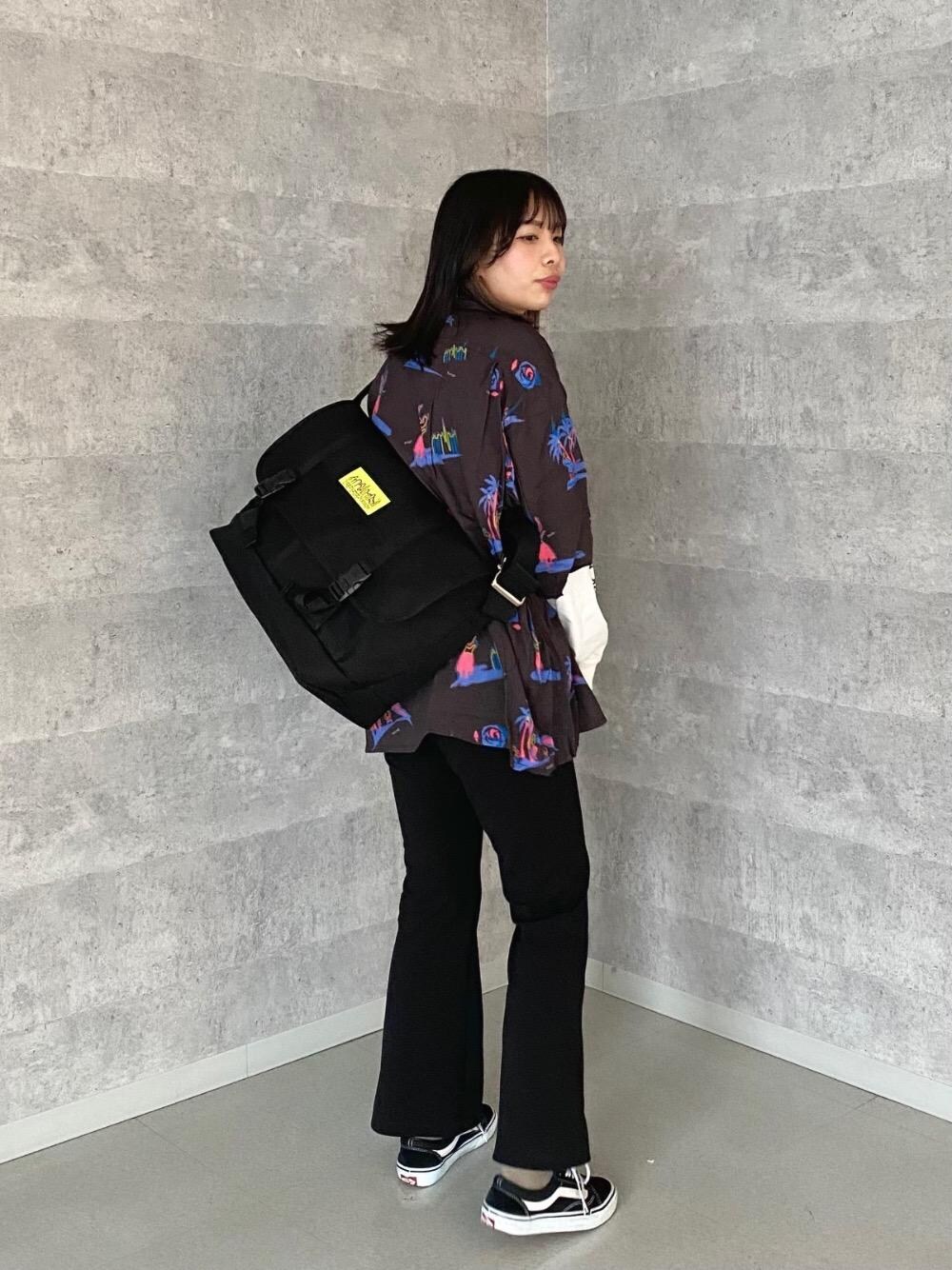 ブラック系のメッセンジャーバッグ、ホワイト系のTシャツ/カットソー、ブラック系のシャツ/ブラウスを着用したレディースの春コーディネートの1枚目の写真