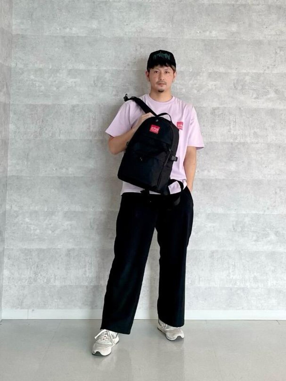 ブラック系のバックパック/リュック、パープル系のTシャツ/カットソーを着用したメンズの春コーディネートの1枚目の写真