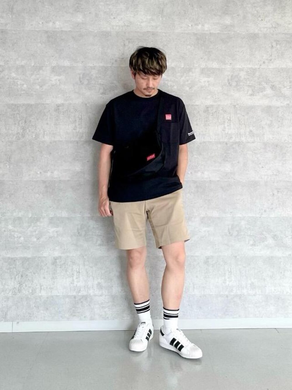 ブラック系のショルダーバッグ、ブラック系のTシャツ/カットソーを着用したメンズの春コーディネートの1枚目の写真