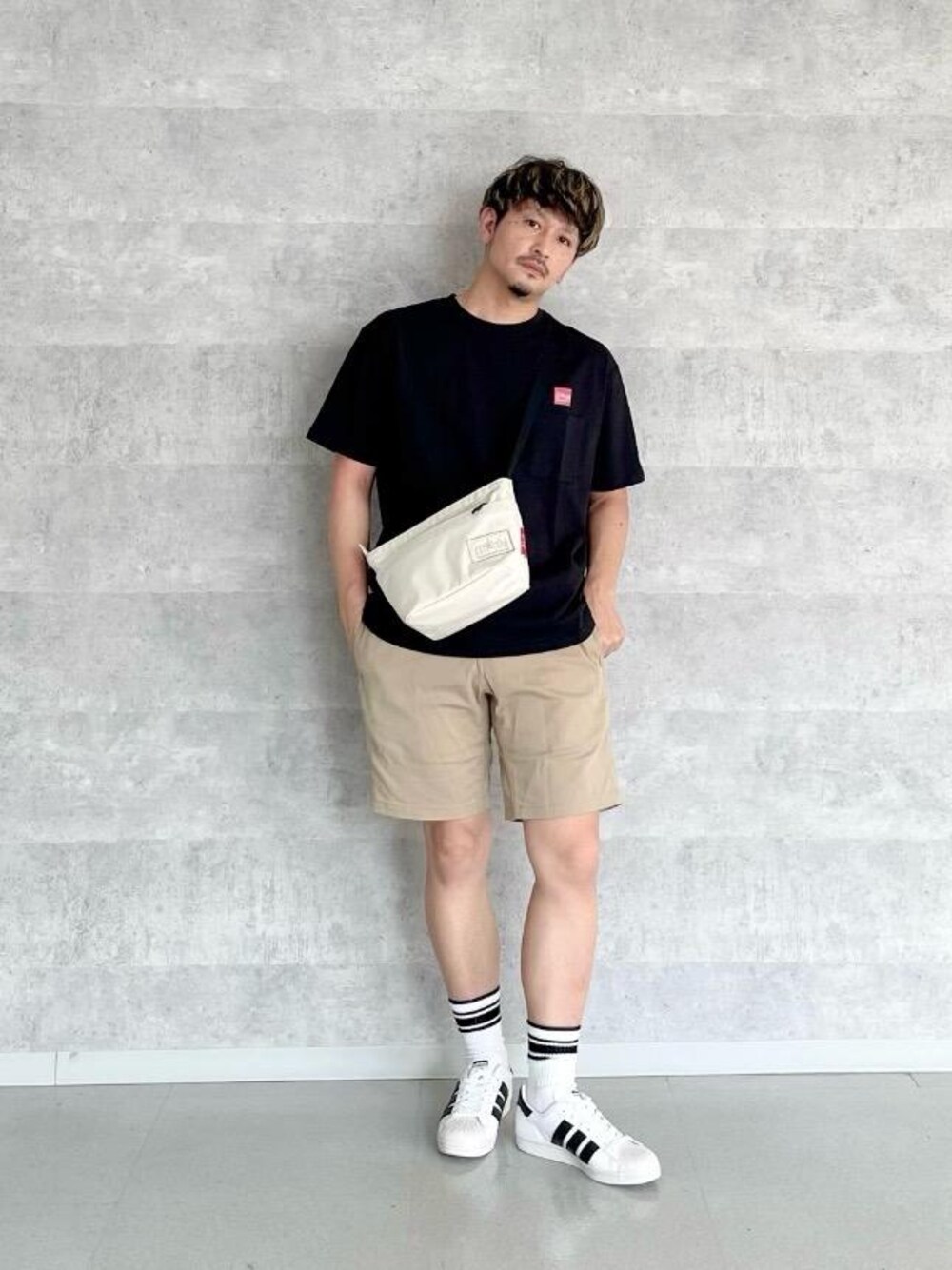 ホワイト系のショルダーバッグ、ブラック系のTシャツ/カットソーを着用したメンズの春コーディネートの1枚目の写真