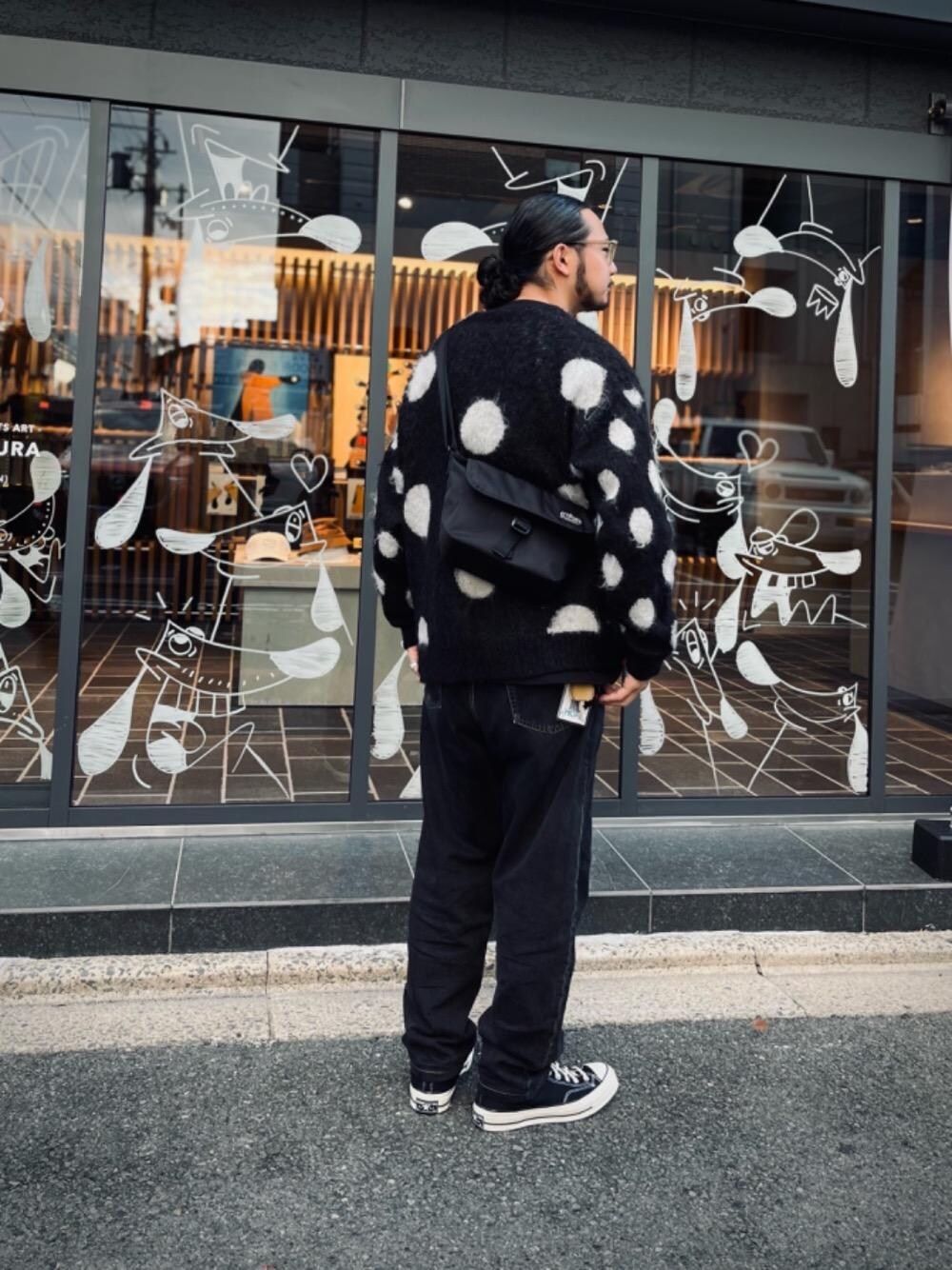 ブラック系のメッセンジャーバッグを着用したメンズの秋コーディネートの1枚目の写真