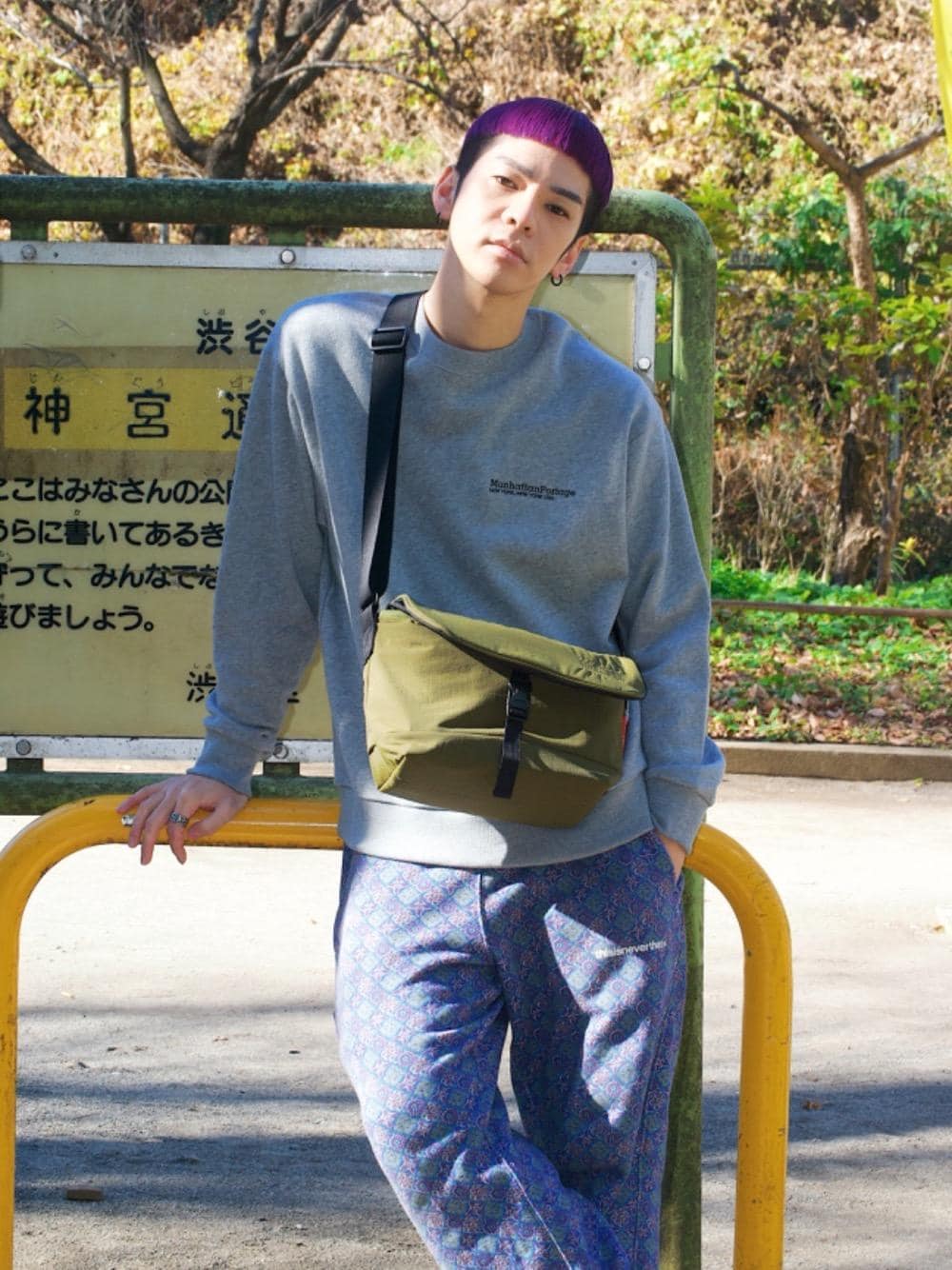 グレー系のスウェット、グリーン系のメッセンジャーバッグを着用したメンズの冬コーディネートの1枚目の写真