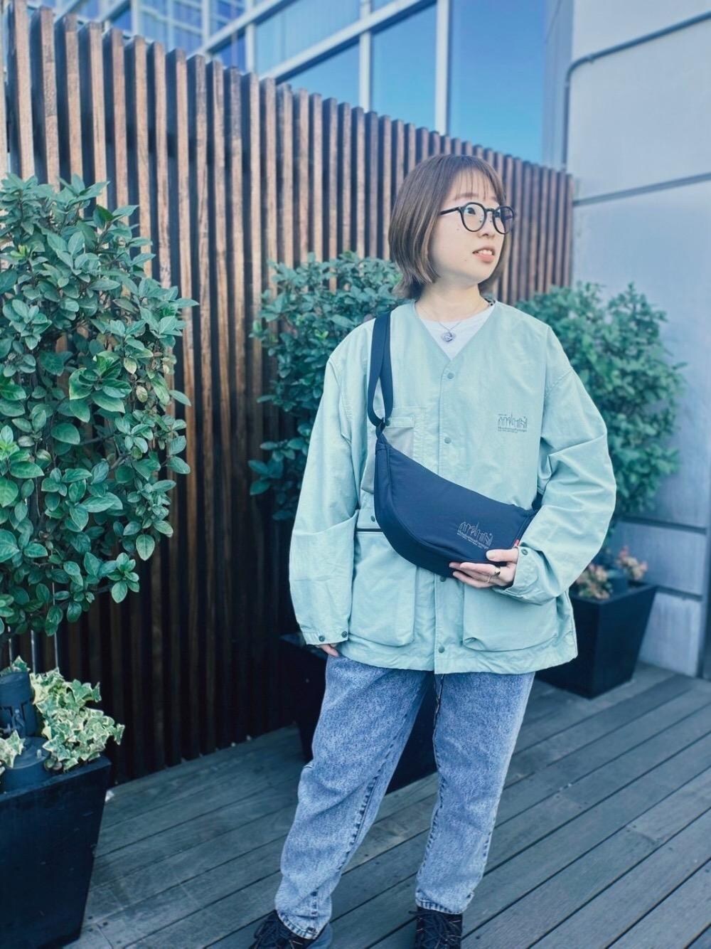 ブラック系のショルダーバッグ、グリーン系のノーカラージャケットを着用したレディースの冬コーディネートの1枚目の写真