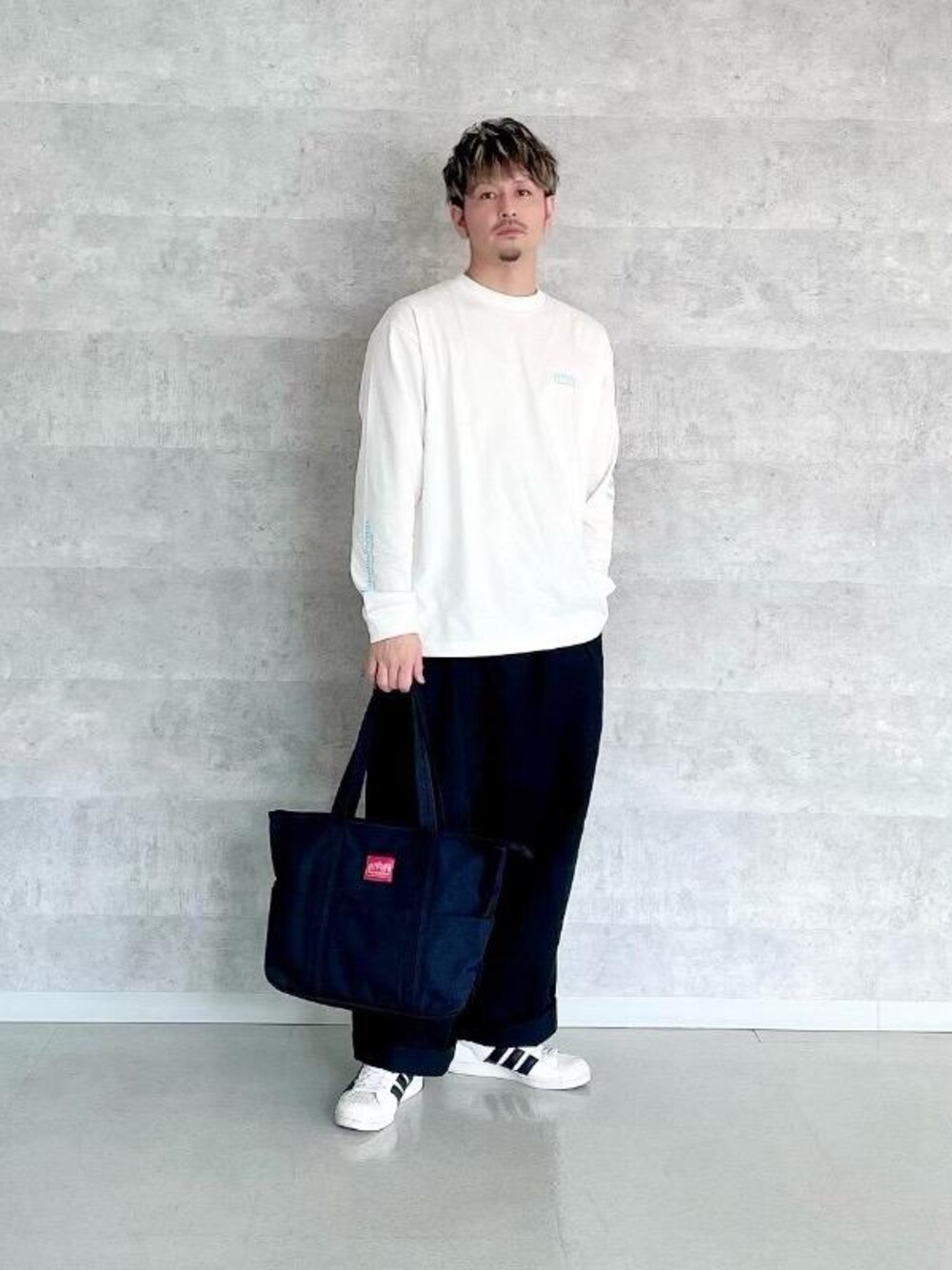 ブラック系のトートバッグ、ブルー系のTシャツ/カットソーを着用したメンズの春コーディネートの1枚目の写真