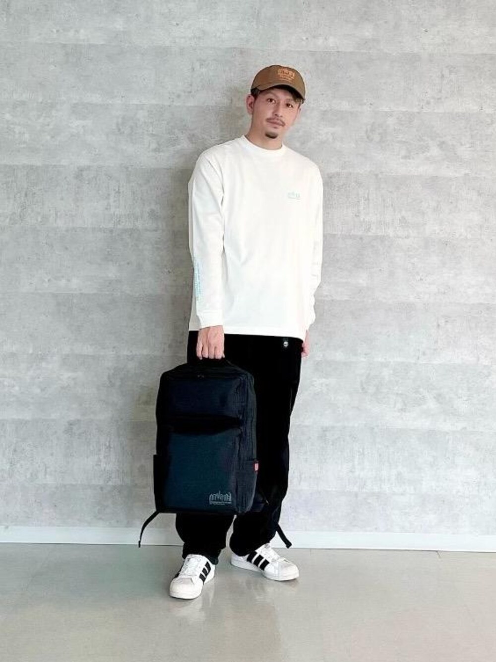 ブラック系のバックパック/リュック、ブルー系のTシャツ/カットソーを着用したメンズの春コーディネートの1枚目の写真