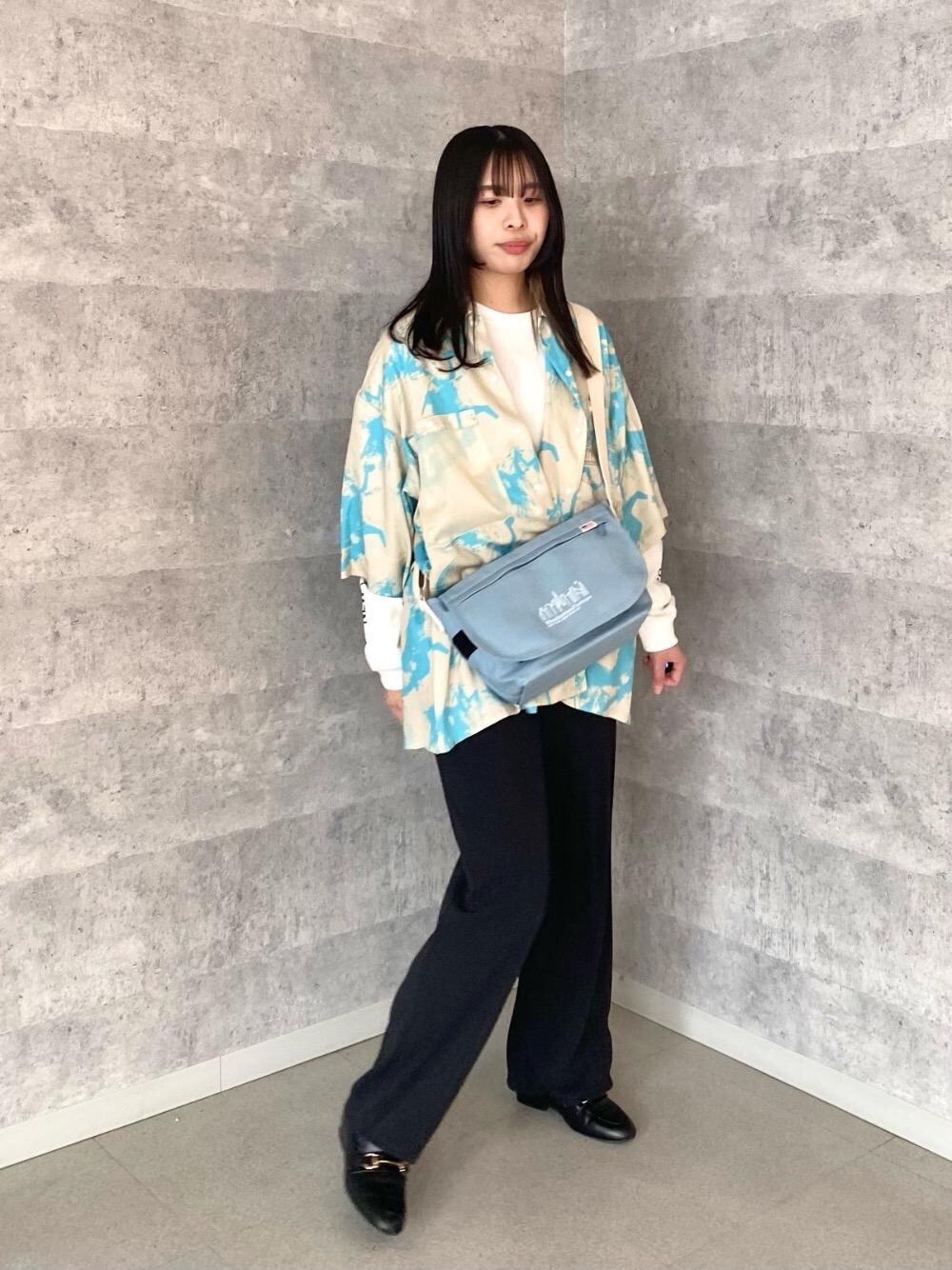 ホワイト系のTシャツ/カットソー、ブルー系のメッセンジャーバッグ、ベージュ系のシャツ/ブラウスを着用したレディースの春コーディネートの1枚目の写真