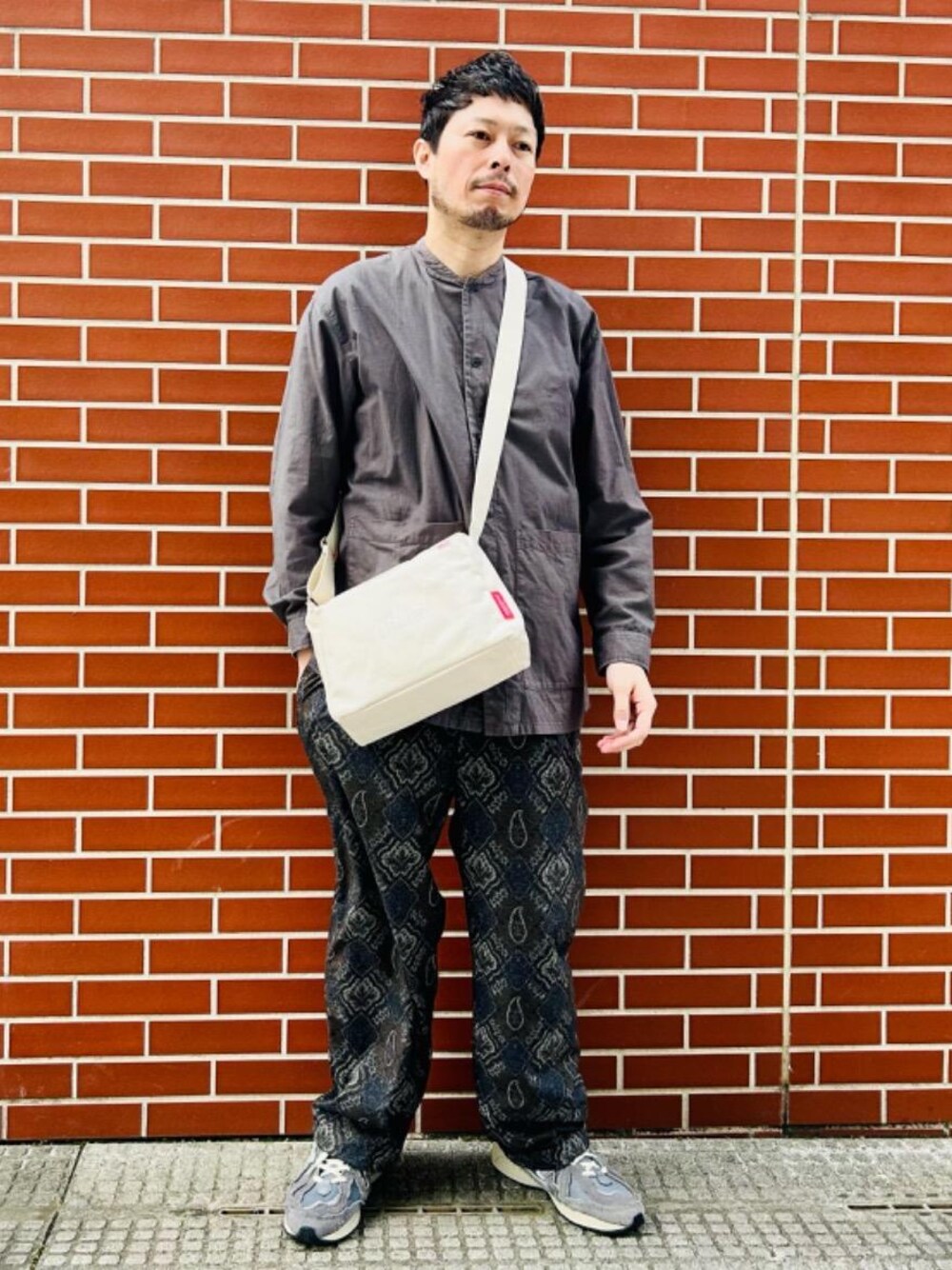 ベージュ系のショルダーバッグを着用したメンズの春コーディネートの1枚目の写真