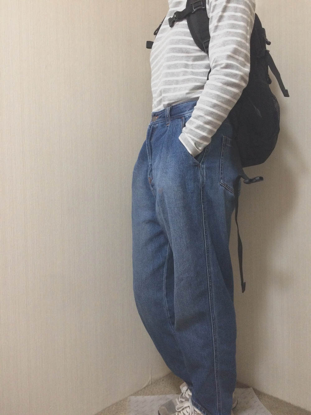 グレー系のTシャツ/カットソー、ブルー系のパンツ、グレー系のスニーカーを着用したレディースの秋コーディネートの1枚目の写真