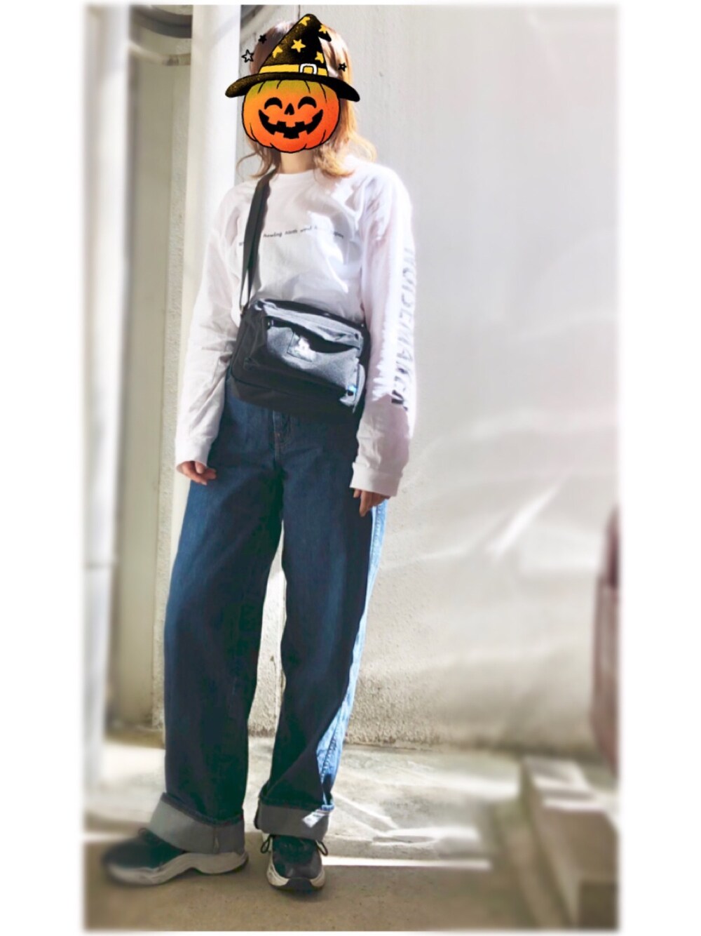 ホワイト系のTシャツ/カットソー、ブルー系のデニムパンツ、ブラック系のスニーカーを着用したレディースの秋コーディネートの1枚目の写真