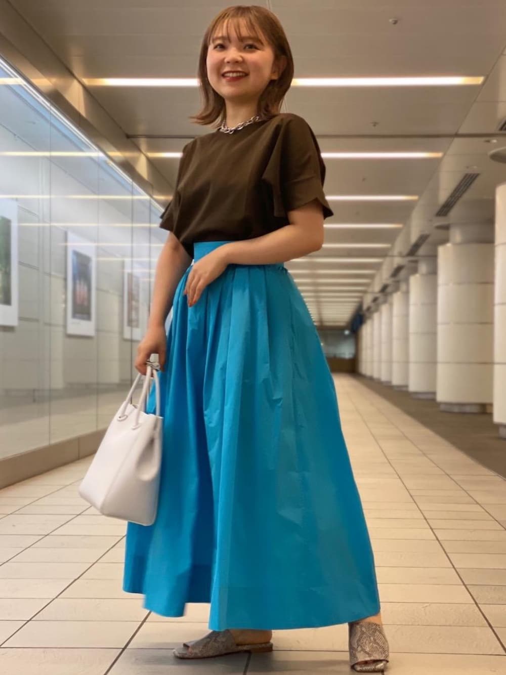 ホワイト系のショルダーバッグ、その他のサンダル、ブルー系のスカートを着用したレディースの夏コーディネートの1枚目の写真