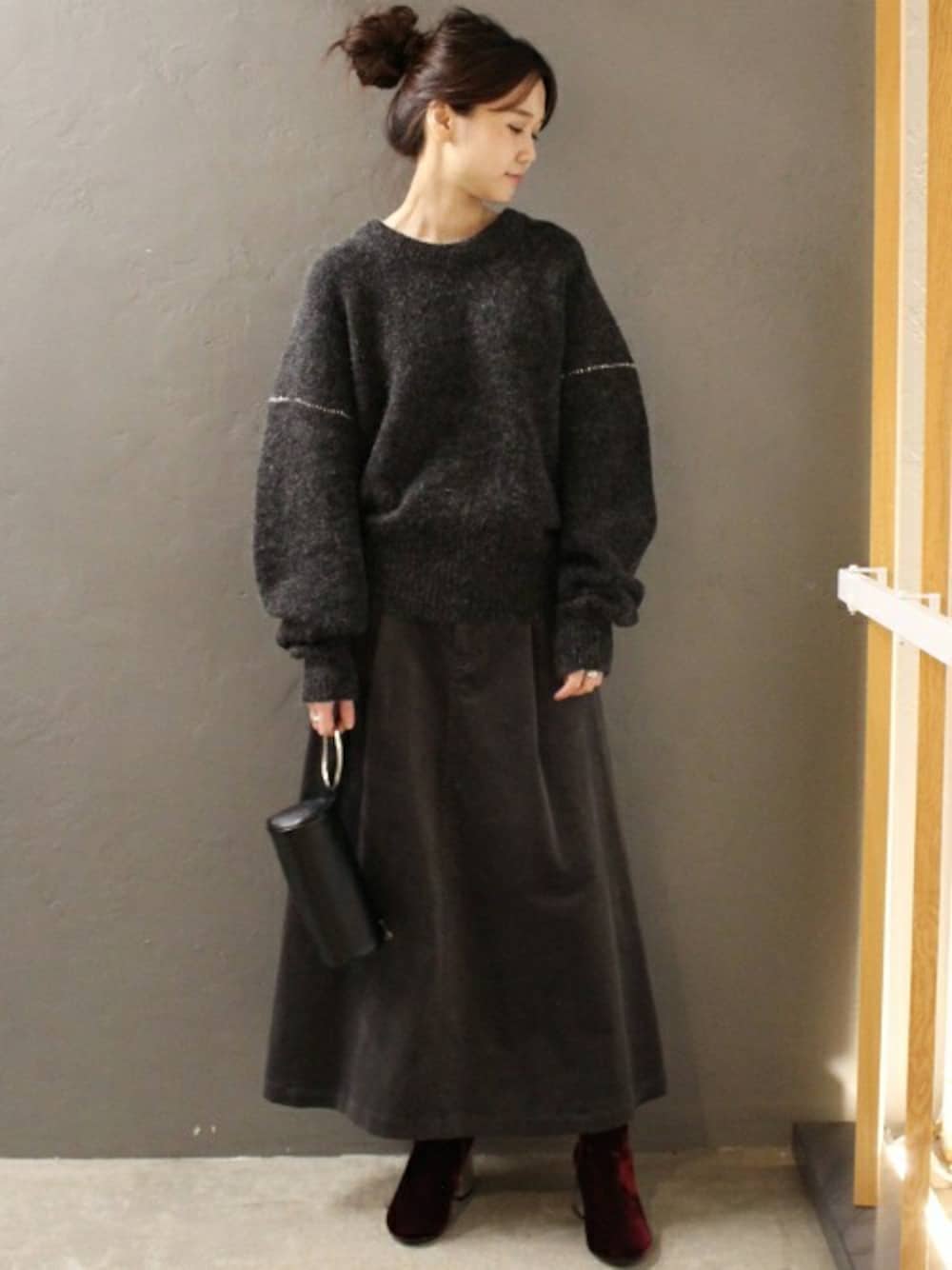 グレー系のスカート、ブラック系のハンドバッグを着用したレディースの秋コーディネートの1枚目の写真