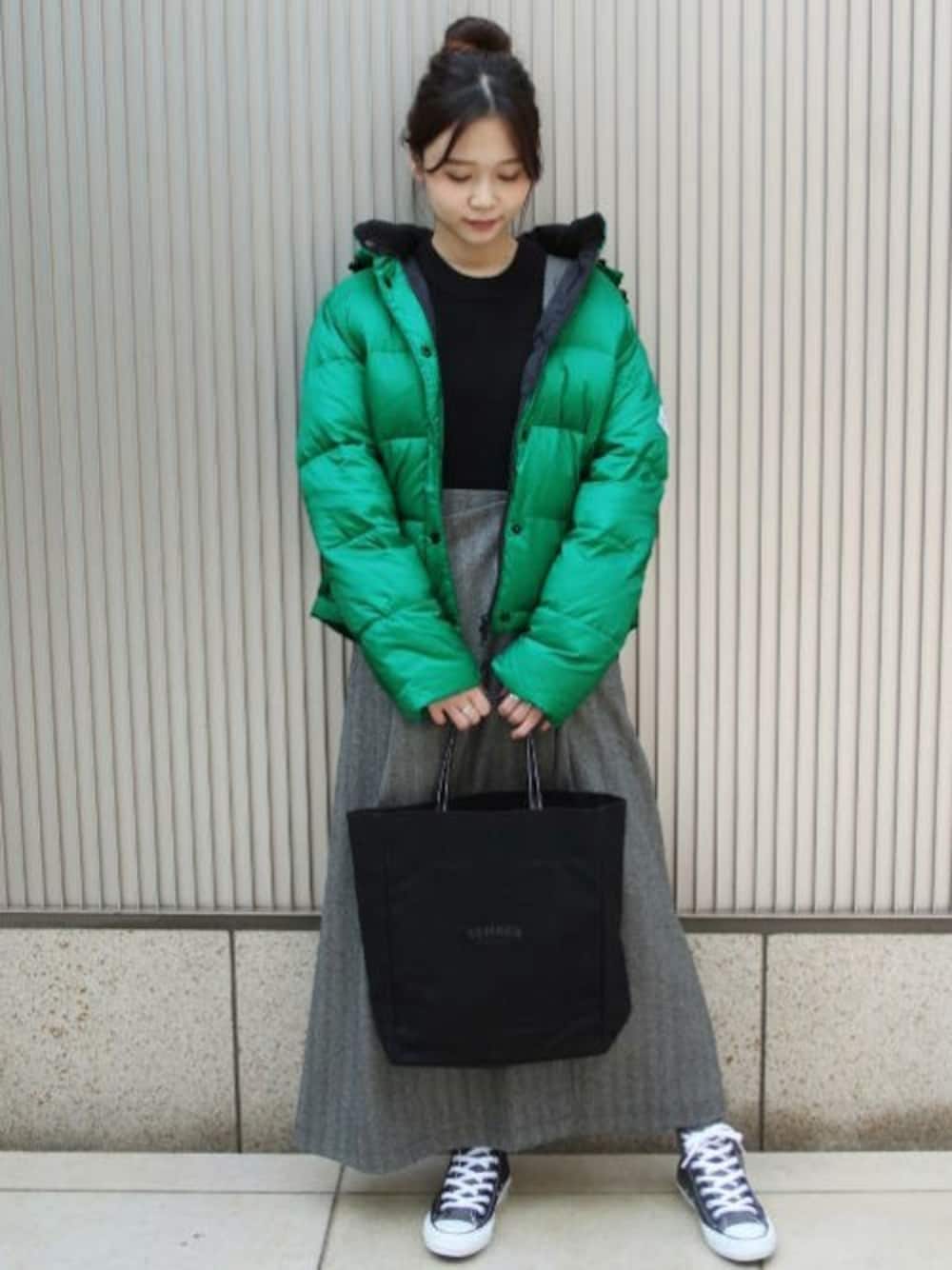 グリーン系のダウンジャケット/コート、グレー系のスカート、ブラック系のトートバッグを着用したレディースの秋コーディネートの1枚目の写真