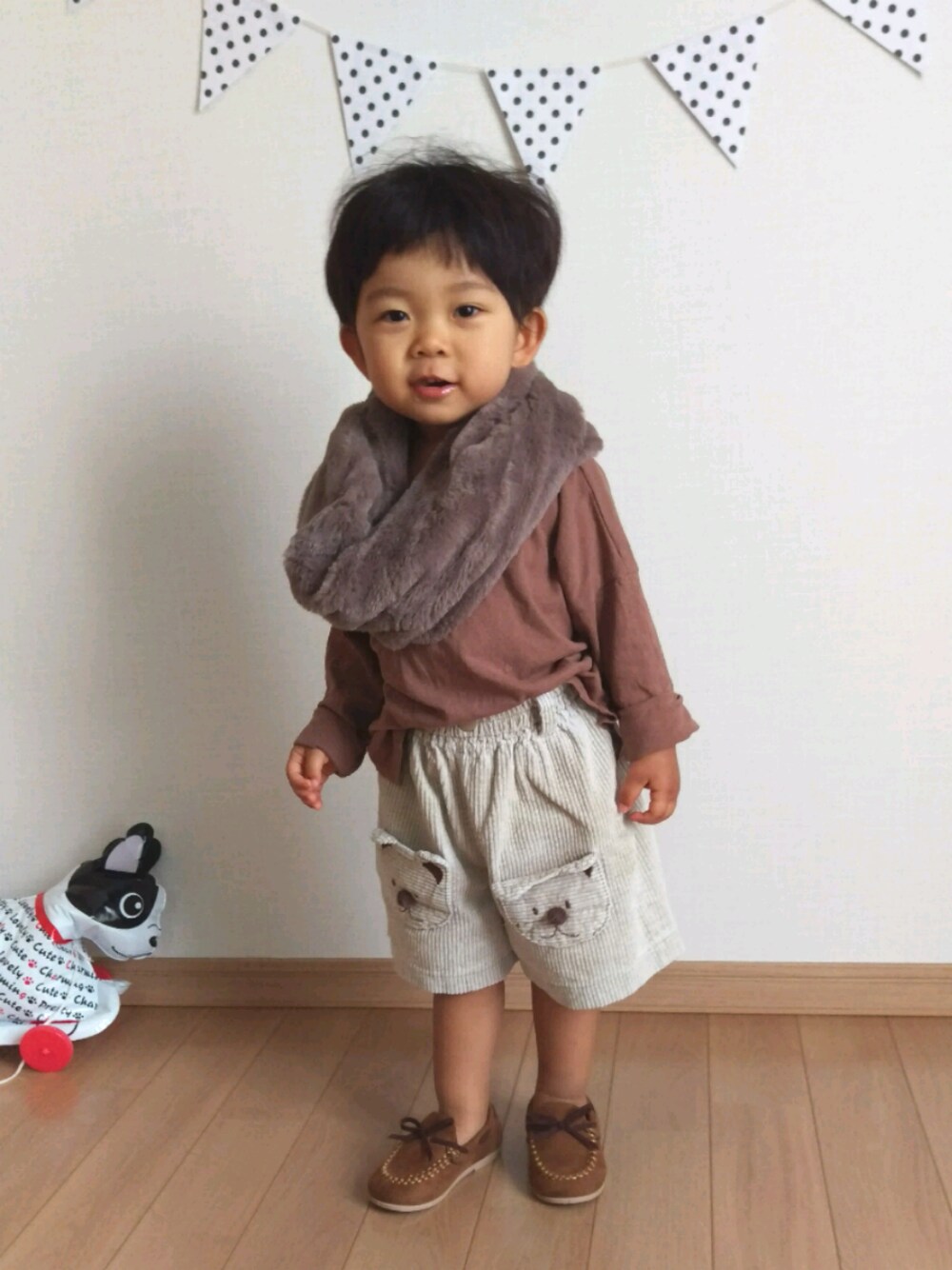 ブラウン系のモカシン/デッキシューズ、ベージュ系のパンツ、ブラウン系のTシャツ/カットソーを着用したキッズの秋コーディネートの1枚目の写真