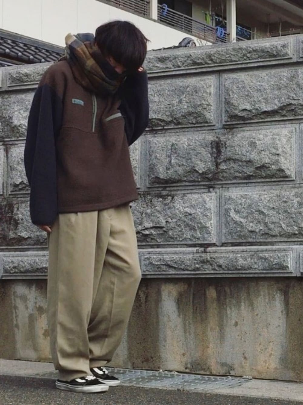 ブラウン系のその他トップス、ベージュ系のスラックス、ブラック系のスニーカーを着用したメンズの冬コーディネートの1枚目の写真