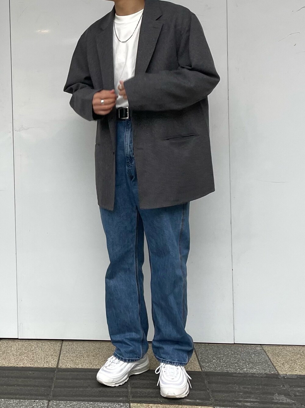 ホワイト系のスニーカー、ブルー系のデニムパンツ、ホワイト系のTシャツ/カットソーを着用したメンズの春コーディネートの1枚目の写真